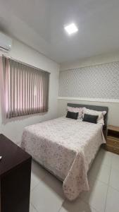 - une chambre avec un grand lit et une couverture rose dans l'établissement Flat completo no centro de Belém, à Belém