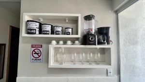 a white shelf with glasses and bottles on it at Flat completo no centro de Belém in Belém