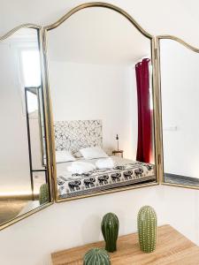 a mirror in a bedroom with a bed and a cactus at CASA RURAL GA7COLORES only adult in Montaña Blanca