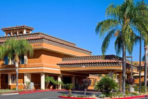 モレノバレーにあるHotel Xolaの前にヤシの木がある建物