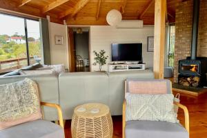 a living room with a couch and a fireplace at HEXAGON BEACH HOUSE Binalong Bay of Fires Views in Binalong Bay