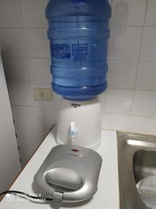 una bottiglia d'acqua è seduta sopra un distributore d'acqua di Moderno y amplio apartamento con vista fantástica en pleno centro a Ciudad del Este
