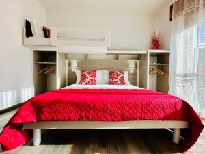 1 dormitorio con 1 cama con edredón rojo en Tropea Family Rooms - B&B Blue Dolphin, en Tropea