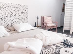 a bedroom with a bed with white sheets and a chair at CASA RURAL GA7COLORES only adult in Montaña Blanca