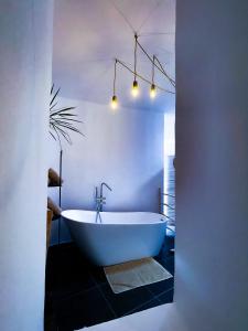 een badkamer met een wit bad en een plant bij hotel rural GA7COLORES only adult in Montaña Blanca