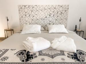 a bed with two towels sitting on top of it at CASA RURAL GA7COLORES only adult in Montaña Blanca