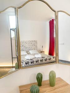 a mirror in a bedroom with a bed and a cactus at CASA RURAL GA7COLORES only adult in Montaña Blanca