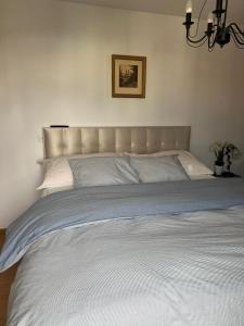 a large bed with white sheets and a headboard at Schweiz (304) in Basel