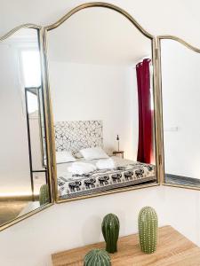 a mirror in a bedroom with a bed and a cactus at CASA RURAL GA7COLORES only adult in Montaña Blanca