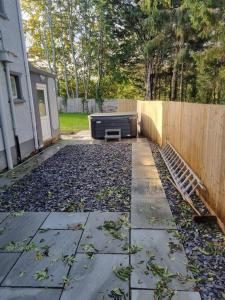 un patio trasero con sofá y valla en 3 Bed Detached House & Hot Tub, en Wrexham