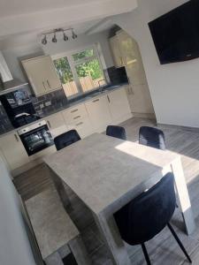 a kitchen with a table and chairs in a room at 3 Bed Detached House & Hot Tub in Wrexham