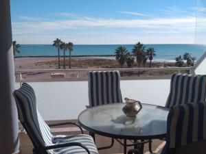 una mesa y sillas con vistas a la playa en Atico Duplex 1ª, en Xilxes