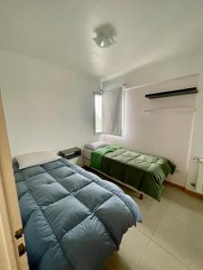 - une chambre avec 2 lits et une fenêtre dans l'établissement Departamentos Leloir, à Neuquén