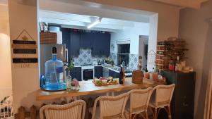 - une cuisine avec une table, des chaises et une bouteille dans l'établissement Our Happy Place, à Natureʼs Valley
