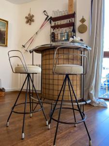 two bar stools in a room with a table at Apartamento Sierra Nevada 7 plazas lujo junto a telesilla estación in Sierra Nevada