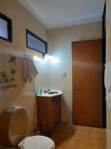 een badkamer met een toilet, een wastafel en een spiegel bij Departamento Brasil in Lunlunta