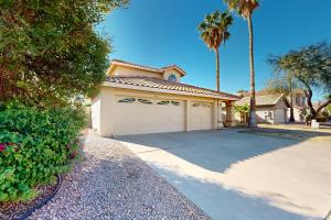 une maison avec un garage et un palmier dans l'établissement Silverwood Getaway, à Phoenix