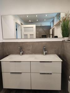 a bathroom with two sinks and a mirror at Ferienhaus Alpenblick 