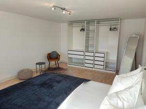 1 dormitorio con 1 cama blanca grande y espejo en Ferienhaus Alpenblick 