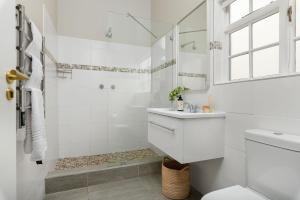 a white bathroom with a shower and a sink at Neighbourgood Franschhoek in Franschhoek +81 photos
