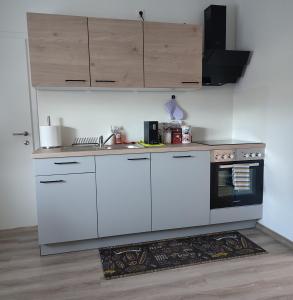 een keuken met witte kasten en een zwarte oven bij Be Home! Apartment Gratkorn in Gratkorn