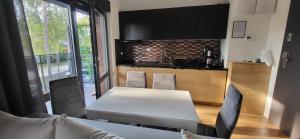 cocina con mesa blanca y sillas en una habitación en Modrzewiowa Apartament z 1 sypialnią, en Niechorze 24 fotos más