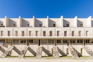 Un grand bâtiment blanc avec des escaliers se trouve juste devant. dans l'établissement Porto Siza Apartment, à Porto