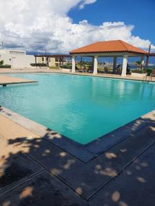 a large blue swimming pool with a gazebo at Bayfront BlueDream Luxurious 1Bed, 1Ba Apt in Portmore