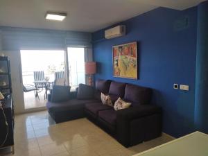 sala de estar con sofá y pared azul en Atico Duplex 1ª, en Xilxes