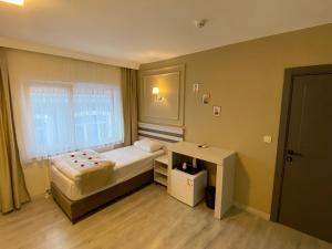 ein kleines Schlafzimmer mit einem Bett und einem Fenster in der Unterkunft GRANDAURA EDıRNE in Edirne