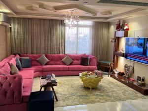 uma sala de estar com um sofá rosa e uma televisão em المقطم,شارع 13,قطعه 331 no Cairo