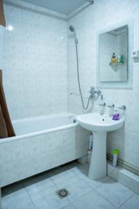 a white bathroom with a sink and a bath tub at Ners Guest House in Gyumri