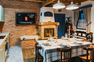 a dining room with a table and a fireplace at Emese Guesthouse in Şiclod