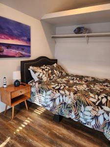 a bedroom with a bed and a night stand with a table at Surf city House in Huntington Beach