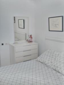 1 dormitorio blanco con 1 cama y vestidor en Atico Duplex 1ª, en Xilxes