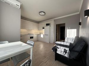 a kitchen and living room with a couch and a table at Kalinova Sloboda Home in Ivano-Frankivsʼk