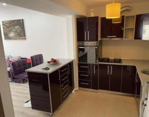 a kitchen with dark brown cabinets and a counter top at MARCY APARTAMENT in Bucharest