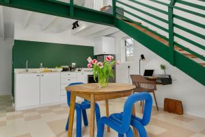 a kitchen with a wooden table and blue chairs at Neighbourgood Franschhoek in Franschhoek