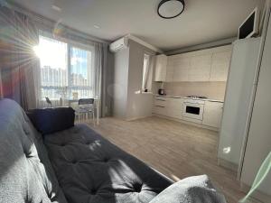a living room with a couch and a kitchen at Kalinova Sloboda Home in Ivano-Frankivsʼk