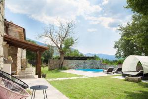 un patio trasero con piscina y una casa en Trohi Home, en Šušnjevica