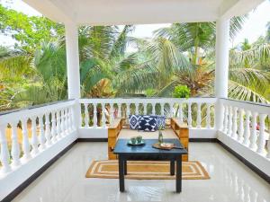 a porch with a bench and palm trees at SOLS Backyard in Arambol