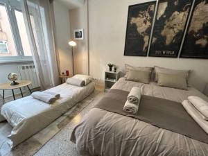 a bedroom with two beds and a table in it at [La Maison du Monde] in Rome