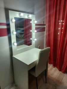 tavolo da trucco con specchio e sedia di Quattro apartment a Zaječar