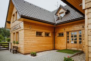 a wooden building with a bench in front of it at Apartmány Velké Karlovice in Velké Karlovice