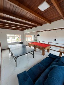 a living room with a couch and a ping pong table at Casa com Piscina temporada in Florianópolis