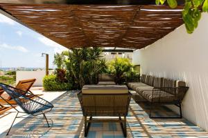 un patio con sofá y sillas en Riva Condos by The Spot Rentals, en Playa del Carmen