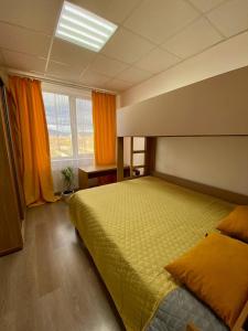 um quarto com uma cama grande com lençóis amarelos em Green Kitchen Apartments em Mukacheve