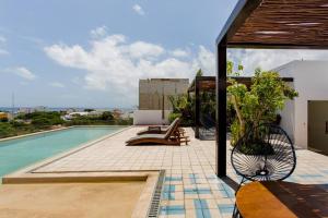 un patio con piscina y una casa en Riva Condos by The Spot Rentals, en Playa del Carmen