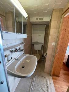 ein Bad mit einem Waschbecken und einem WC in der Unterkunft Chalet le Domino - Proche des pistes et des bains in Ovronnaz