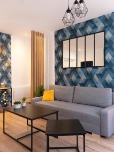 a living room with a couch and a table at ClairChêne - Cosy Centre Parking Spacieux Familial in Verdun